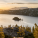 Sunset over Lake of Bays with snow-capped trees and golden sunlight piercing through, offered by Jayne's Luxury Rentals for top winter activities