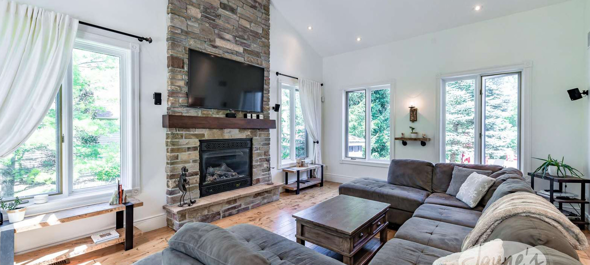 Inviting living room with fireplace and panoramic lake views at Jayne's Luxurious Rentals property.
