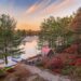 Sunset at A Loon's Lottery in Gravenhurst - Jayne's Luxurious Rentals | Serene lake view with colorful foliage and a quaint boathouse