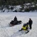 Snowmobiling Adventure at Jayne's Luxurious Rentals | Guests enjoying a snowmobile trail with a scenic frozen waterfall backdrop
