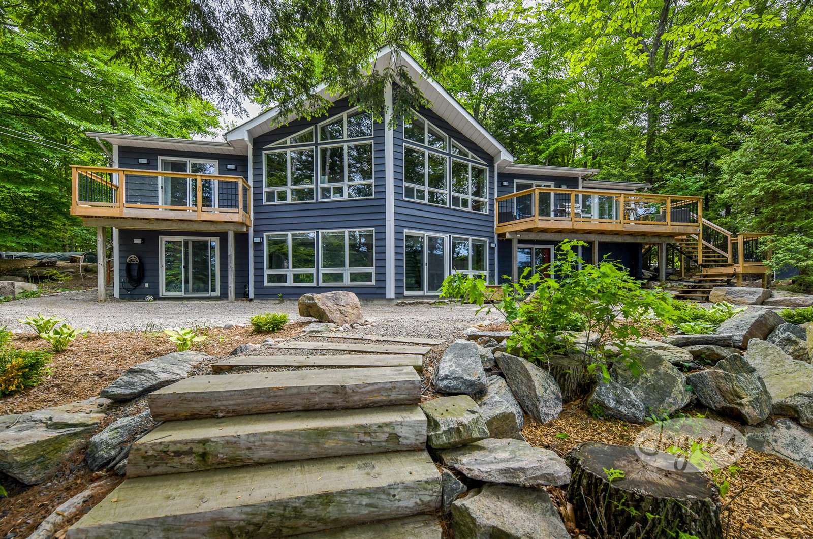 Clarity on Clear Lake property in Canada - Jayne's Luxurious Rentals | A spacious retreat with large windows nestled among lush greenery