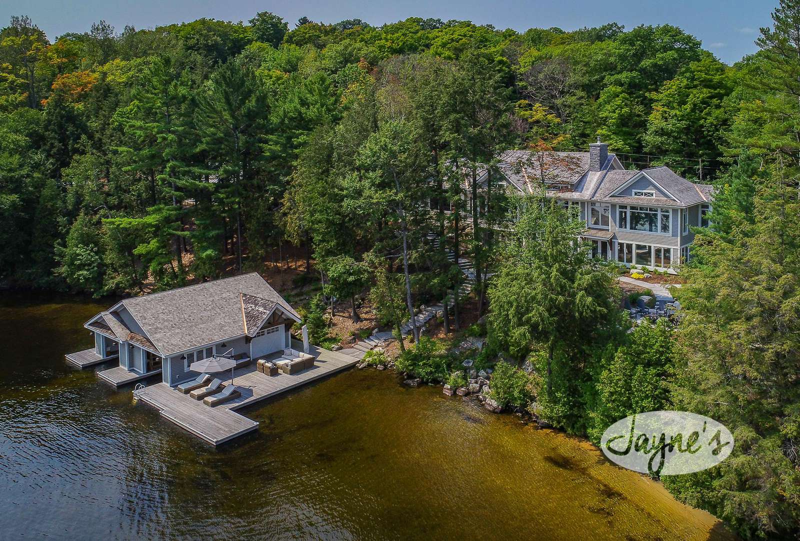 Kismet Cottage on Lake Rosseau - Jayne's Luxurious Rentals | Aerial view showcasing the elegant lakefront property with a private boathouse