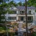 The Shimmering Waters property in Dwight - Jayne's Luxurious Rentals | Elegant white two-story home with natural stone landscaping