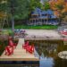 The Canopy - Lakeside property with dock and red chairs - Jayne's Luxurious Rentals | Peaceful waterfront and vibrant autumn trees