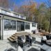 Lakeside patio of White Opal property in Ontario - Jayne's Luxurious Rentals | Chic outdoor furniture set against a backdrop of autumn trees
