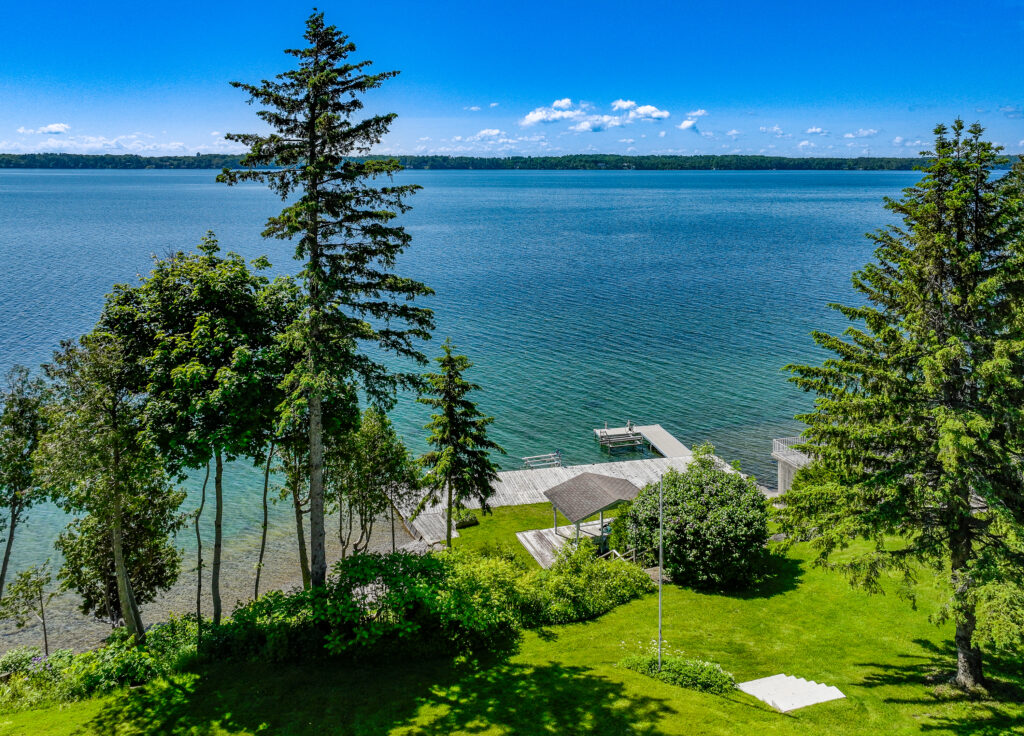 Aerial view of Manor Ridge property with lush greenery and private dock on Lake Simcoe West Shore - Jayne's Luxury Rentals.