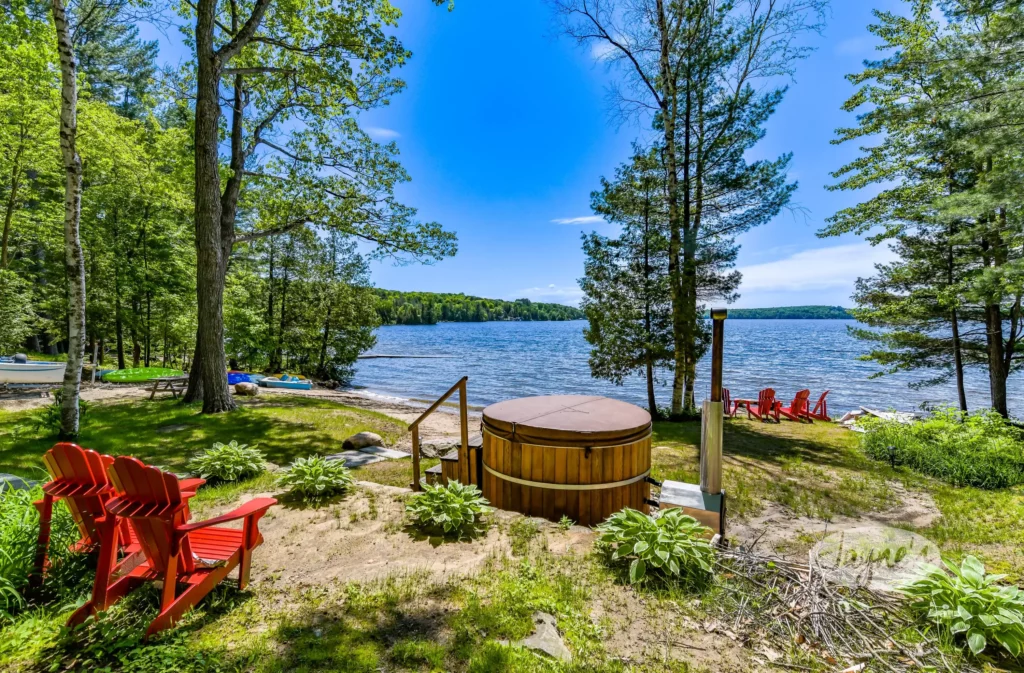 Cozy wood-fired hot tub and Adirondack chairs at The Homestead, Lake of Bays, a serene escape offered by Jayne's Luxury Rentals.