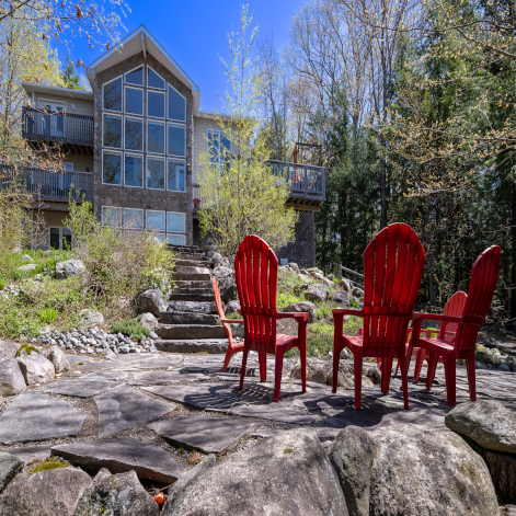Sold Luxurious Property Luminous on Stewart - Port Carling | Stone Patio with Red Chairs | Jayne's Luxury Rentals