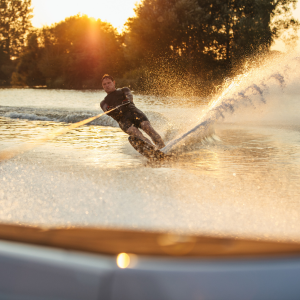 Adventurous guest waterskiing at sunset - Luxury water sports experience with Jayne's Luxury Rentals