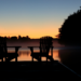Silhouette of a leisurely boat ride at sunset in Muskoka, capturing the tranquil beauty of the lake as part of the concierge services offered.