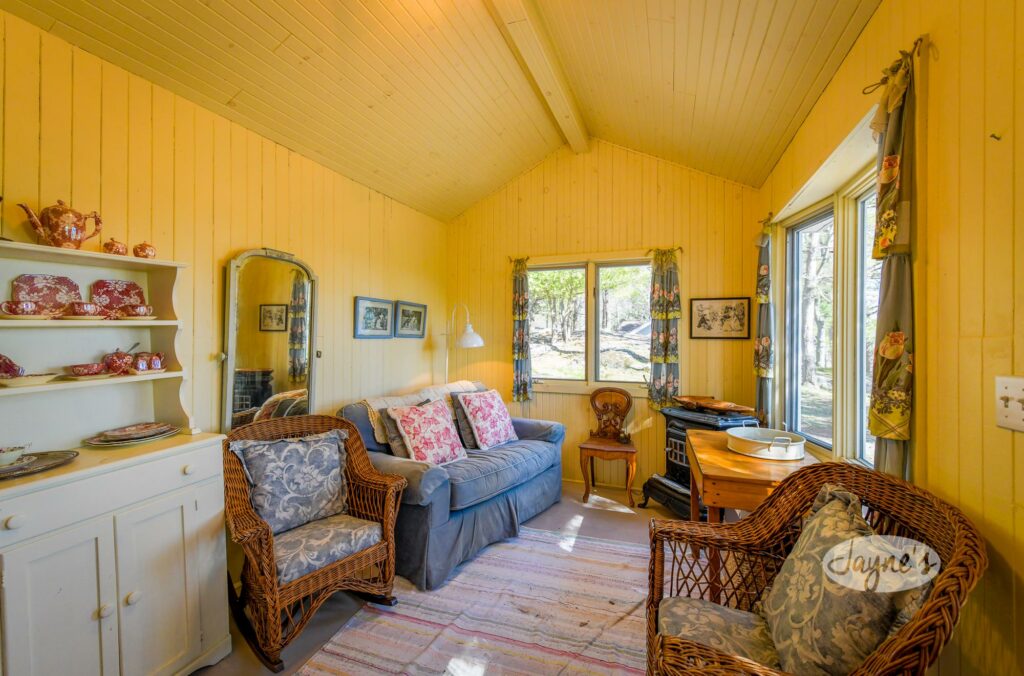 Charming and cozy cottage interior with vintage furnishings and warm natural light - Jayne's Luxurious Rentals.