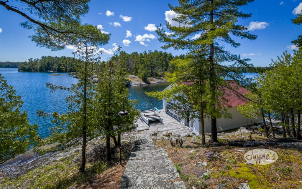 Luxurious lakeside cabin with a private dock amidst the tranquil beauty of towering pines - Jayne's Luxurious Rentals.
